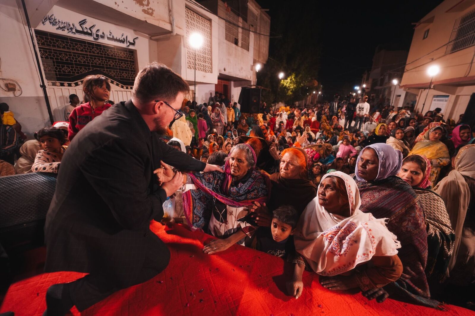 Praying with women seated in a Karachi street at night