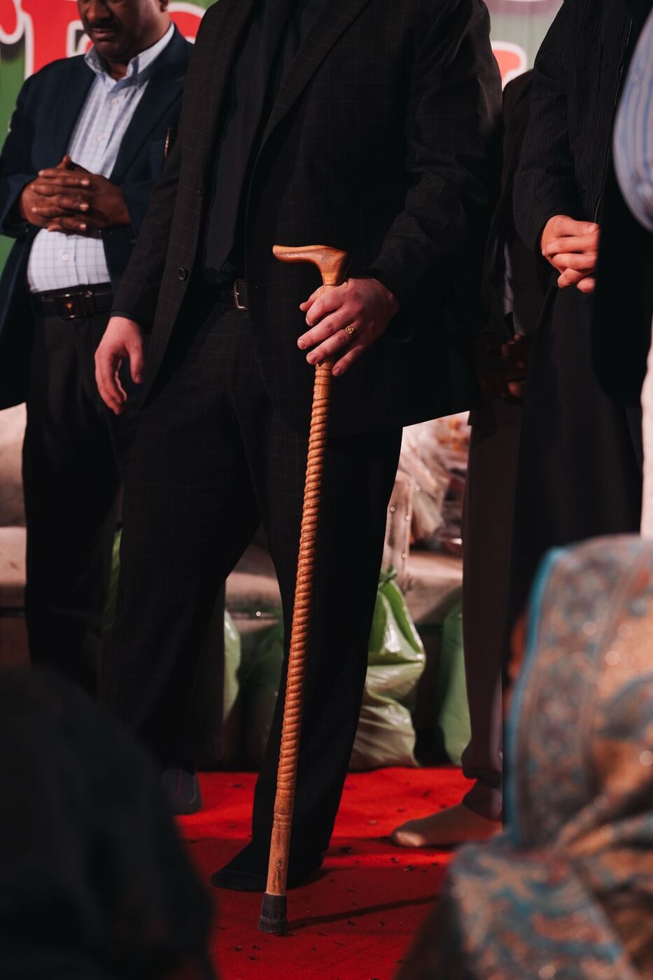 Pastor Holland on the crusade stage holding the cane of a man who no longer needs it