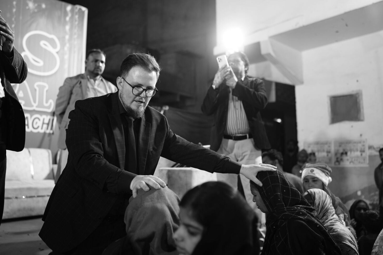 Praying over people at the crusade, in black and white
