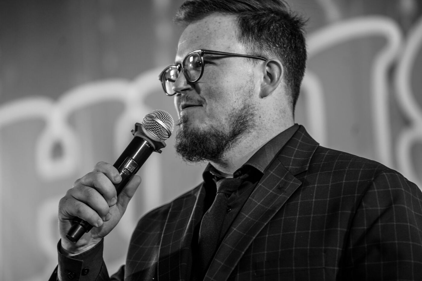 Preaching into the microphone, in black and white